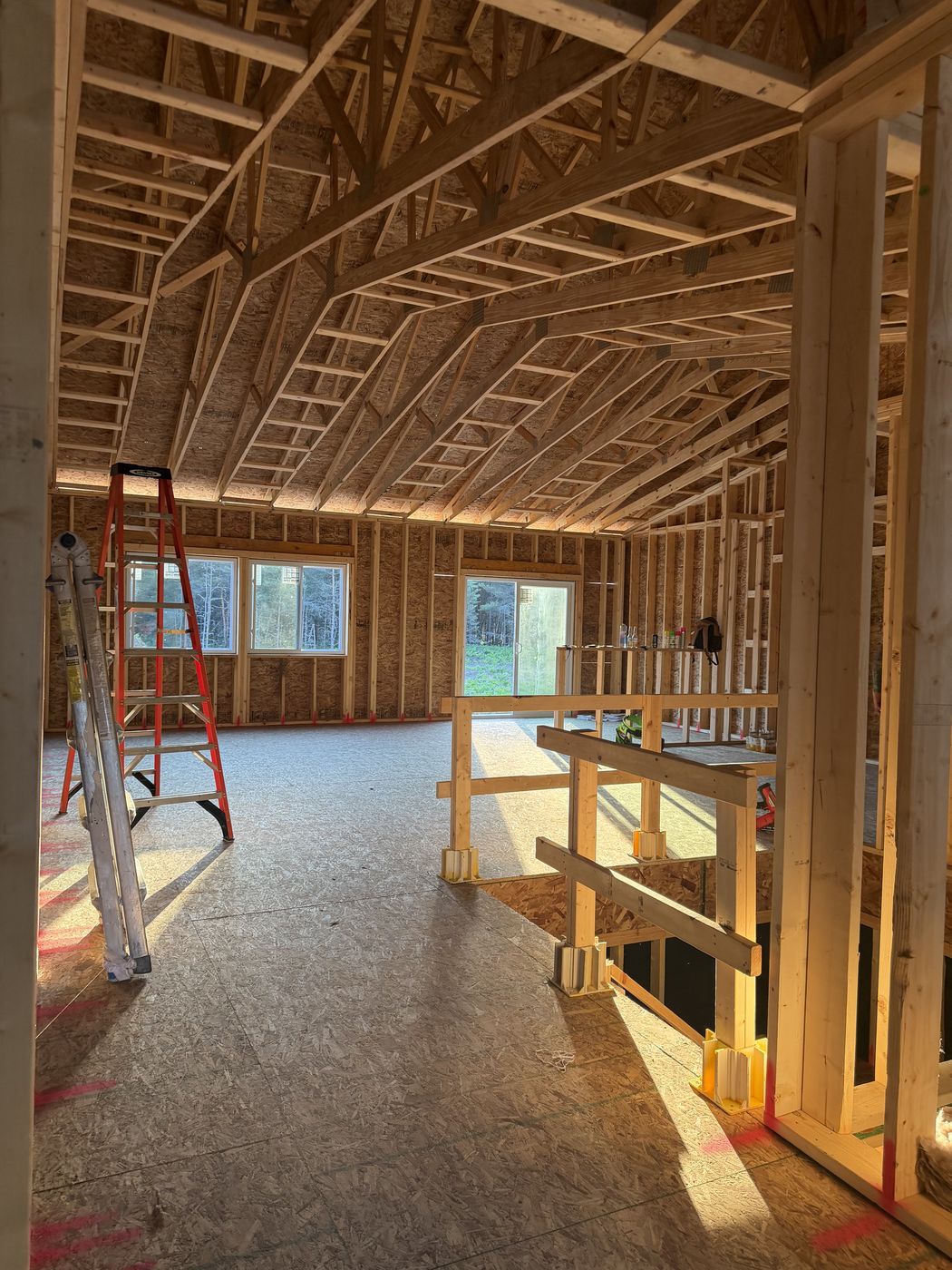 Before: open roof trusses and framing seen from the stair opening